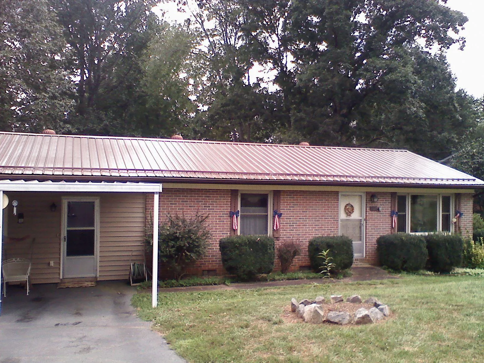 Bronze metal roof and carport on a brick ranch home — Roof Repair work by our crew in Cottageville